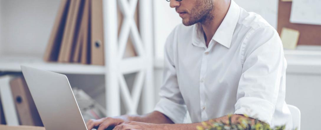 un homme au bureau sur son ordinateur portable