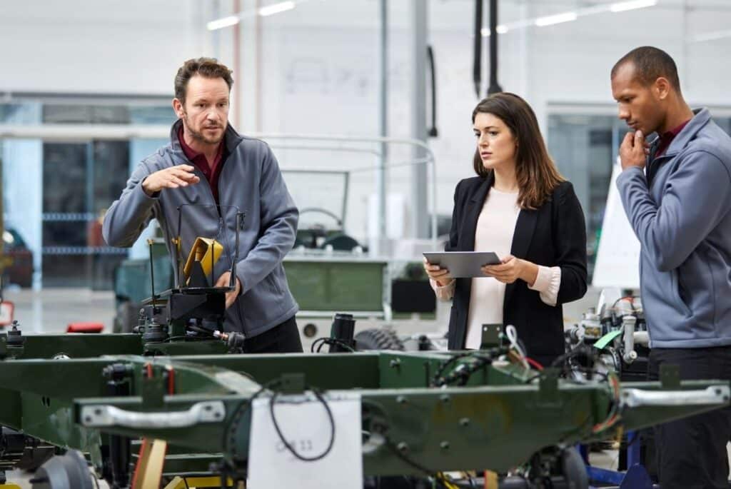 Responsables analysant les conditions de travail dans un atelier industriel dans le cadre d’une démarche d’évaluation des risques professionnels.