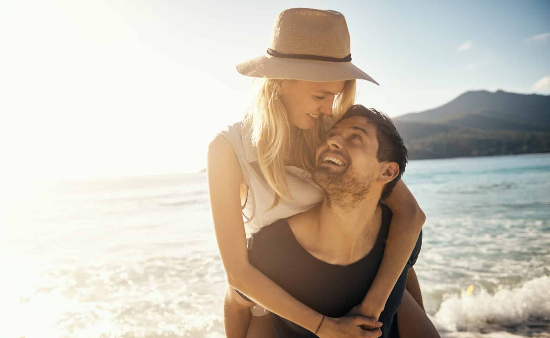 Deux personnes sur une plage ensoleillée près de la mer.
