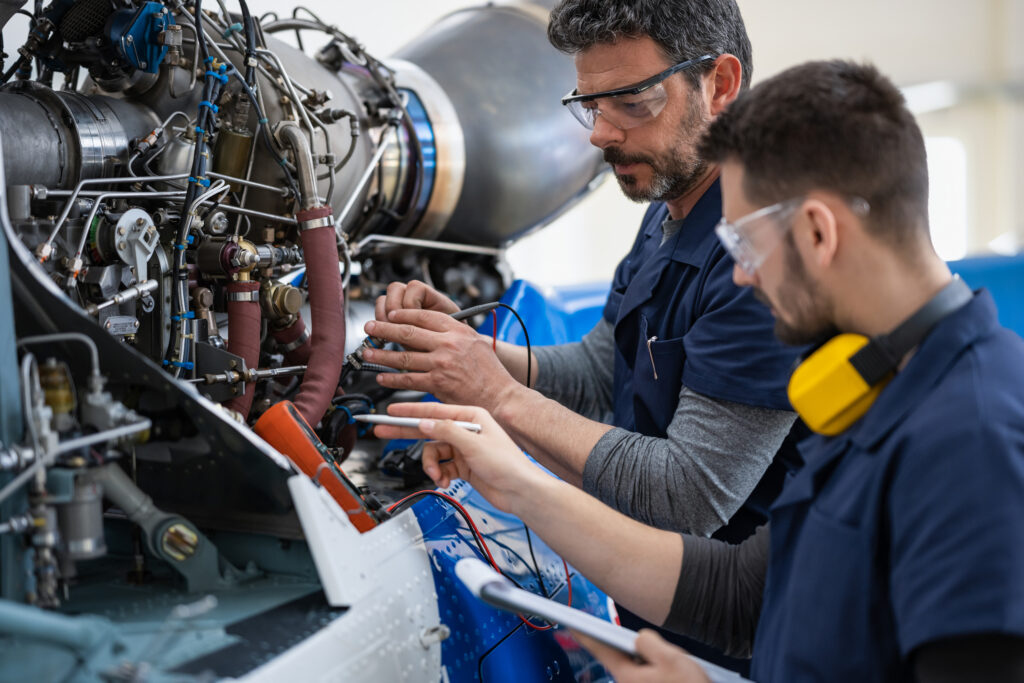 Intervention technique sur un moteur aéronautique en atelier, illustrant l’expertise industrielle du secteur aéronautique et spatial