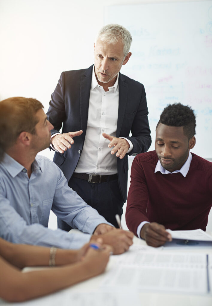 Réunion de travail entre plusieurs professionnels autour de documents.