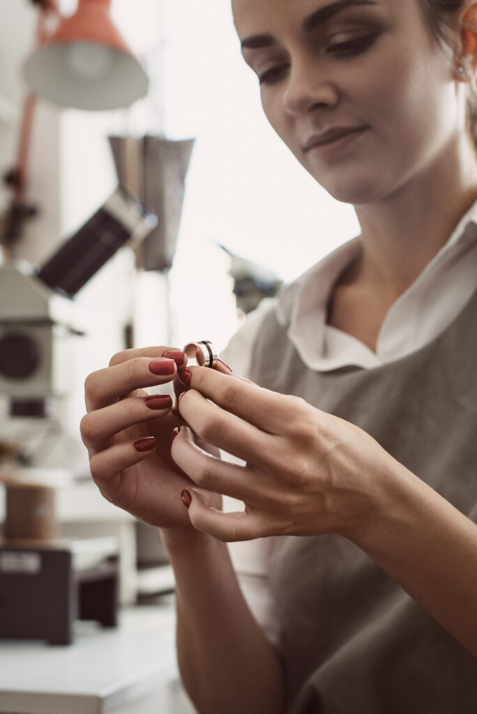 Manipulation minutieuse d’un bijou en atelier de joaillerie, illustrant un travail de précision et de finition.