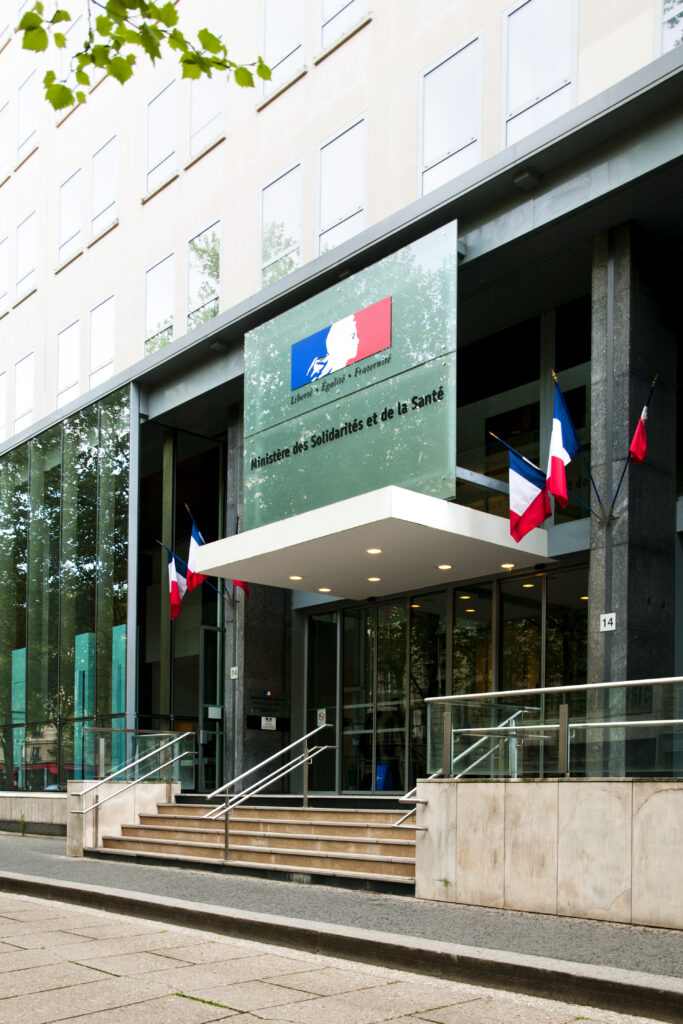 Bâtiment administratif de l’État français abritant des services publics, avec signalétique institutionnelle et drapeaux nationaux.