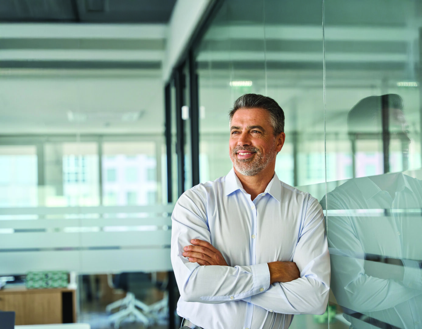 Dirigeant se tenant dans un environnement de bureaux modernes, symbole de responsabilité et de gouvernance.