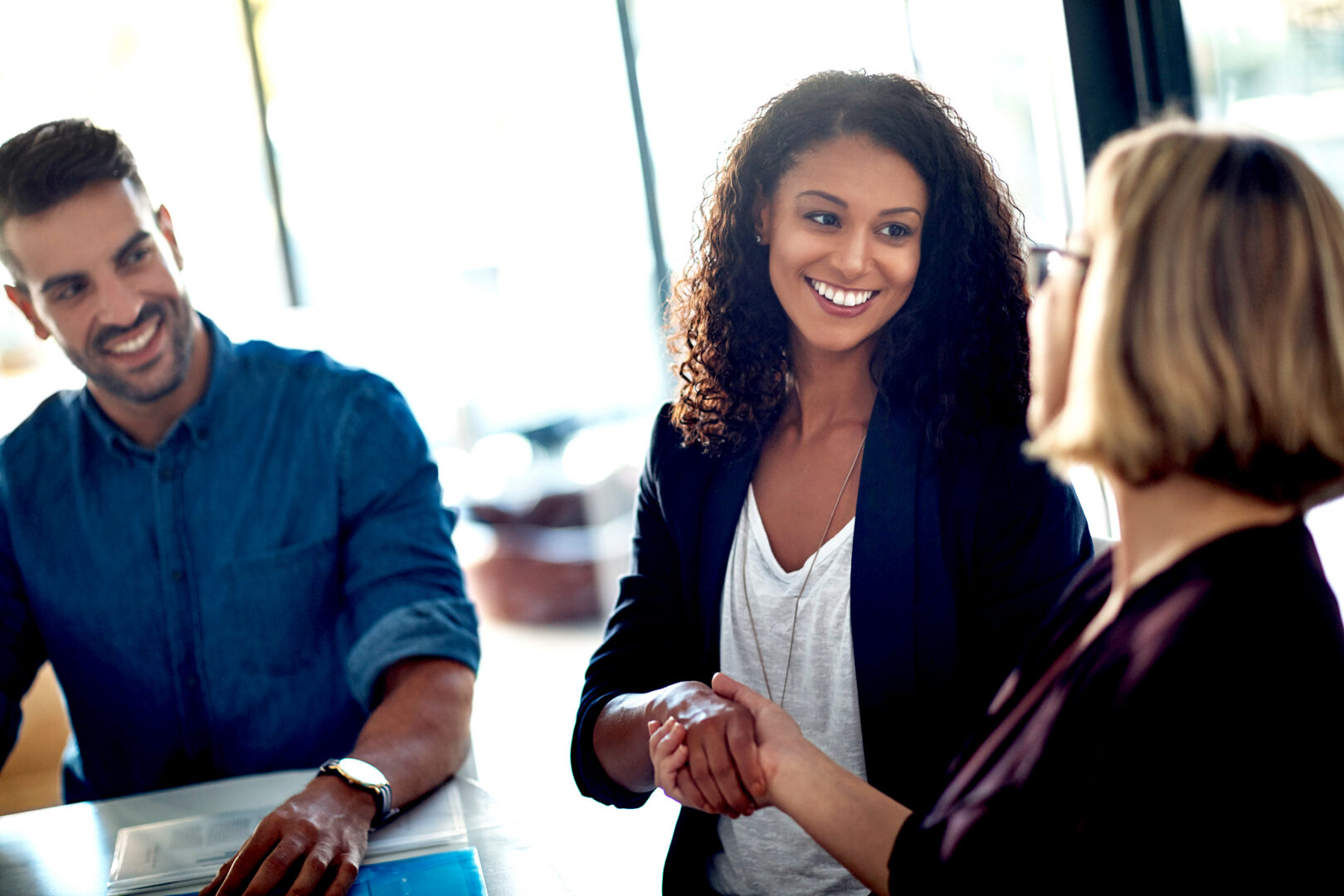 Échange professionnel entre plusieurs collaborateurs dans un environnement de travail moderne, illustrant la coopération et l’écoute.