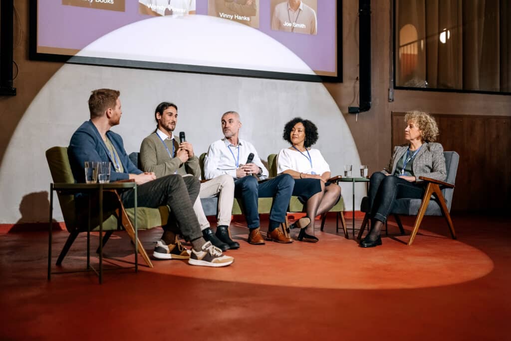 Intervenants participant à une table ronde lors d’une conférence professionnelle, dans un espace dédié aux échanges et aux débats.
