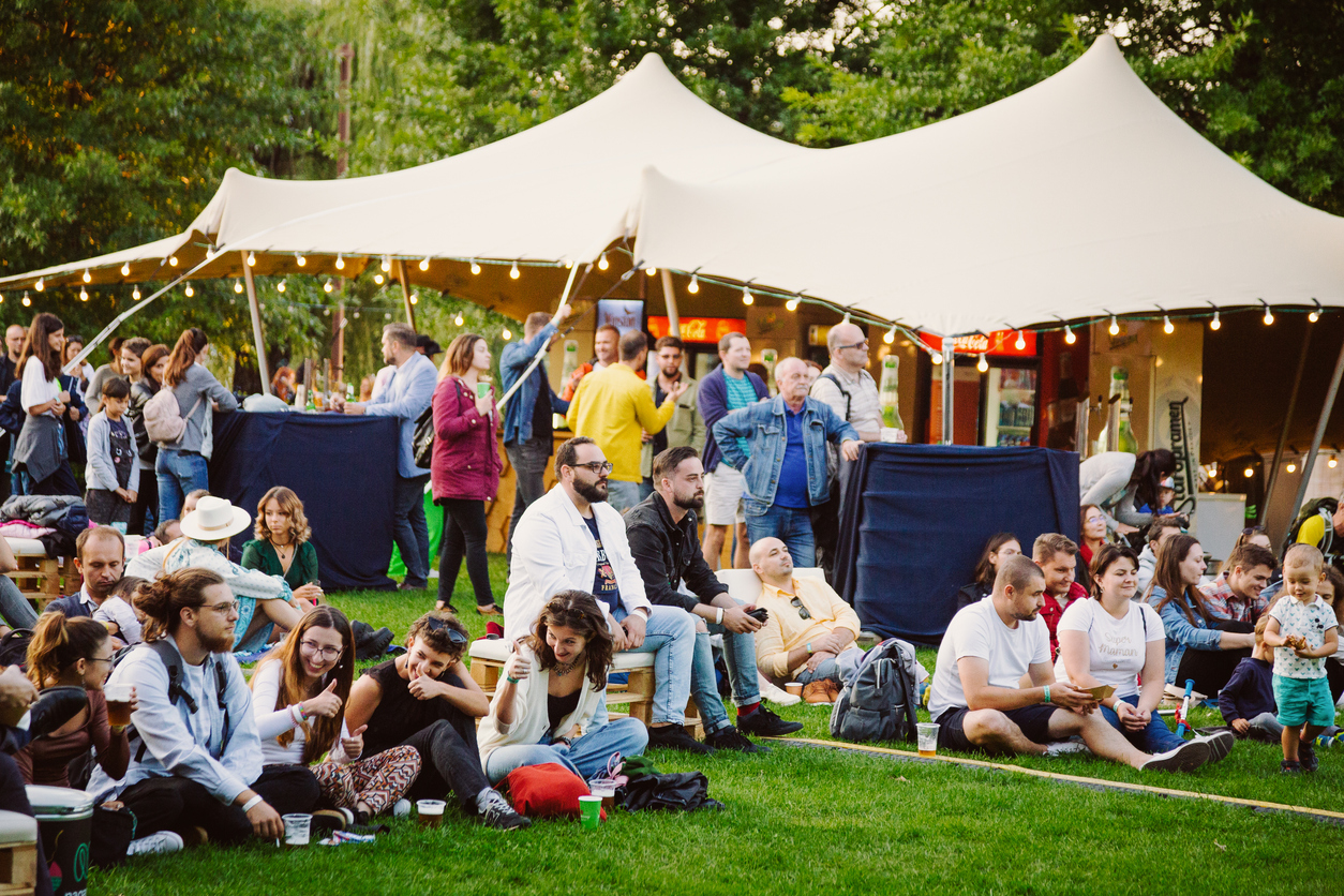 Public réuni lors d’un événement en extérieur avec des structures temporaires et des espaces de convivialité.