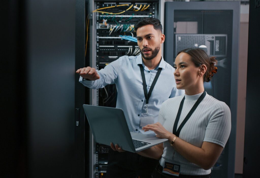 Deux professionnels analysant une infrastructure informatique dans une salle serveur