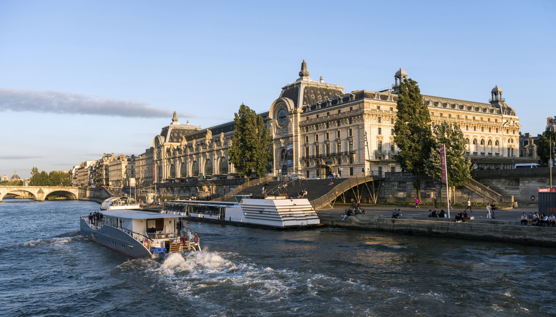 Façade du musée d’Orsay vue depuis la Seine au soleil couchant.