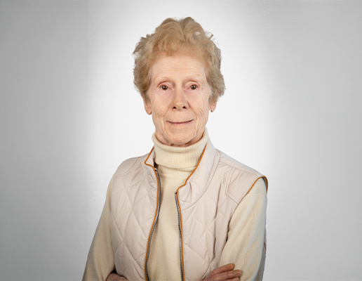 Portrait professionnel d’une personne en costume sur fond neutre.